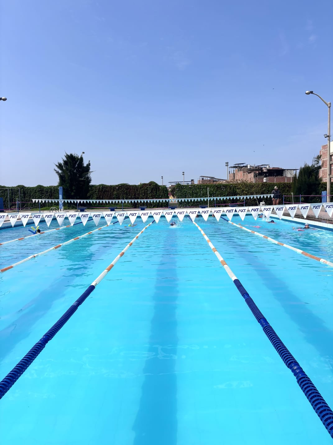Carriles de la piscina de AXT Trujillo bajo un cielo despejado.