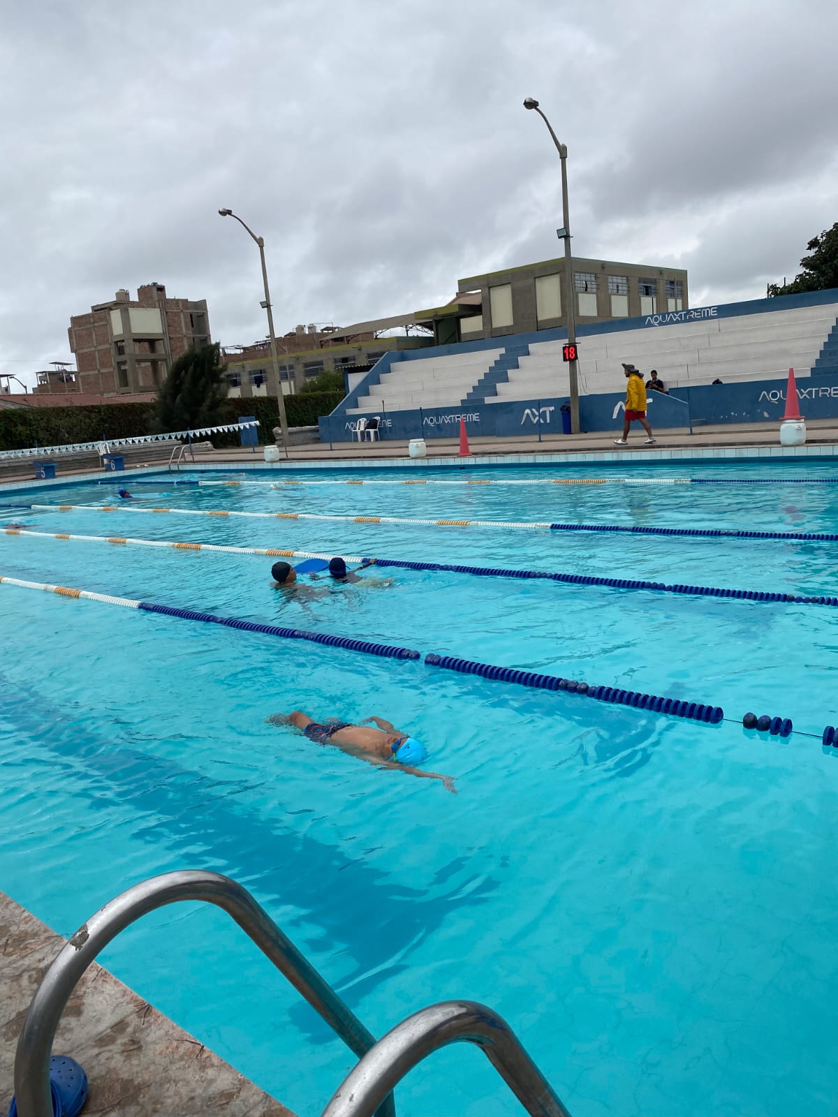 Nadadores entrenando en los carriles de la piscina de AXT Trujillo.